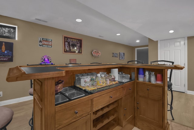 bar featuring recessed lighting, baseboards, and light wood finished floors