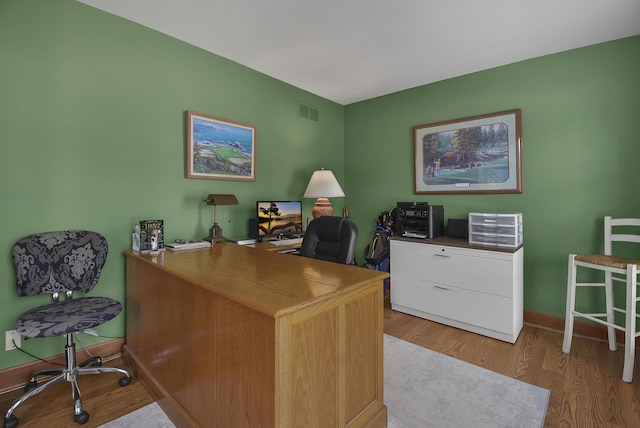 office area with visible vents, baseboards, and wood finished floors