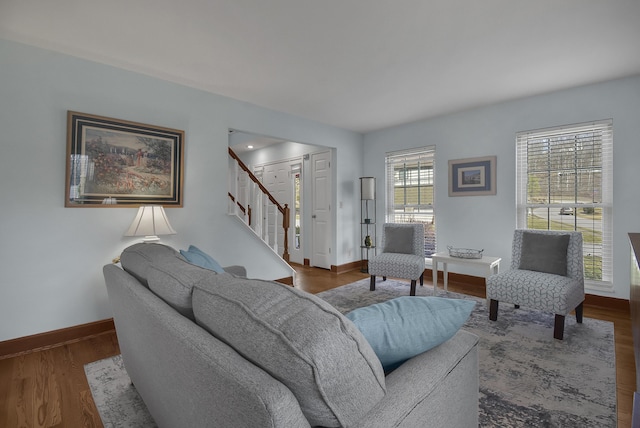 living room with stairs, wood finished floors, and baseboards