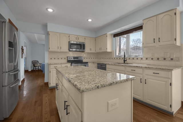 kitchen featuring dark wood finished floors, a center island, a sink, and stainless steel appliances