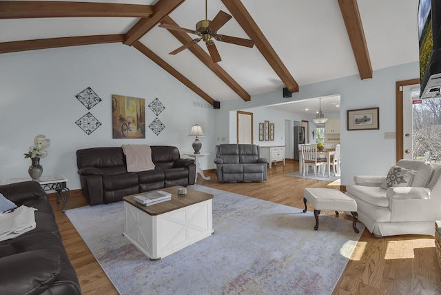 living room featuring a ceiling fan, beamed ceiling, light wood-style floors, and high vaulted ceiling