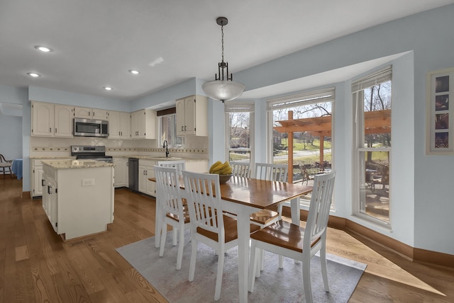 dining room with recessed lighting, baseboards, and dark wood-type flooring