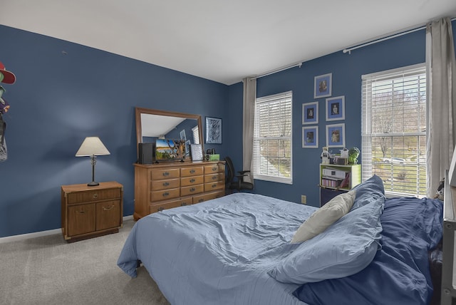 bedroom featuring carpet flooring, multiple windows, and baseboards