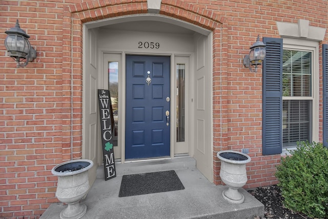 entrance to property featuring brick siding