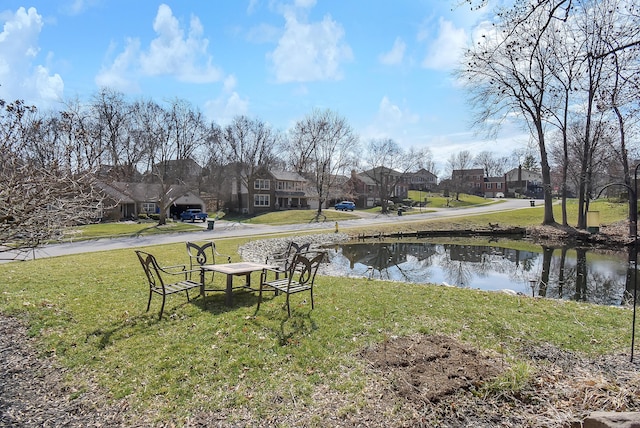 view of yard with a residential view and a water view