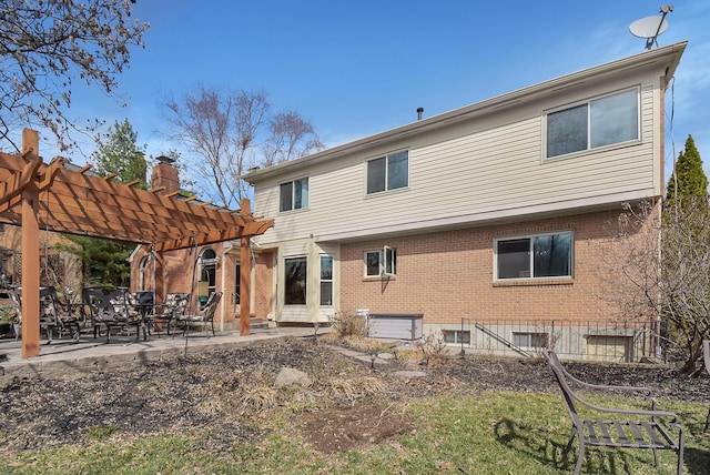 back of house with a pergola, a patio area, and brick siding