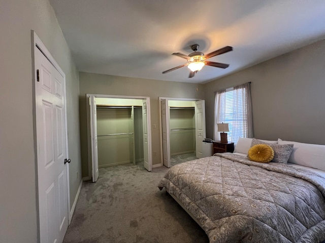 bedroom featuring two closets, ceiling fan, and carpet