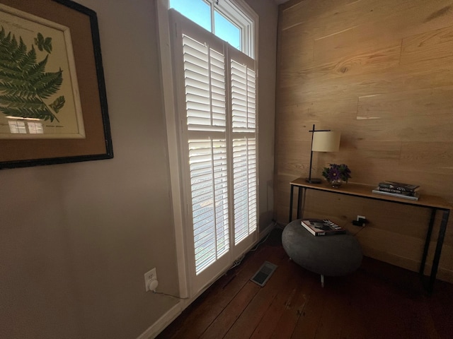 interior space with wood-type flooring and wood walls