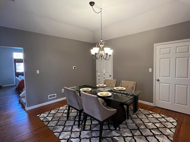 dining room featuring dark wood-type flooring and an inviting chandelier