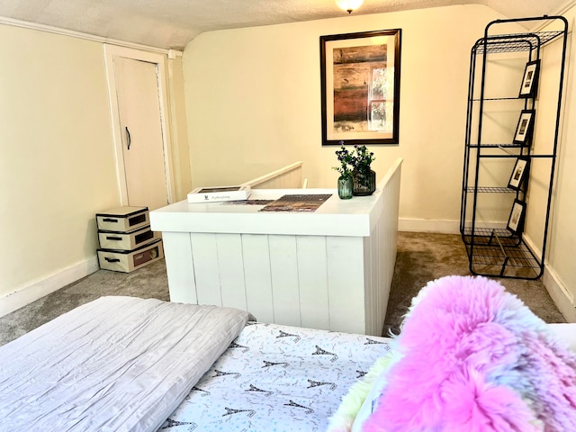 bedroom with vaulted ceiling, a textured ceiling, and dark colored carpet