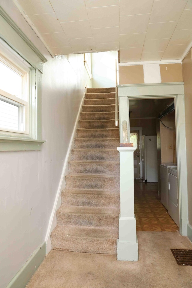 stairs featuring carpet and washing machine and dryer