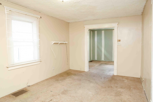 carpeted spare room featuring a textured ceiling