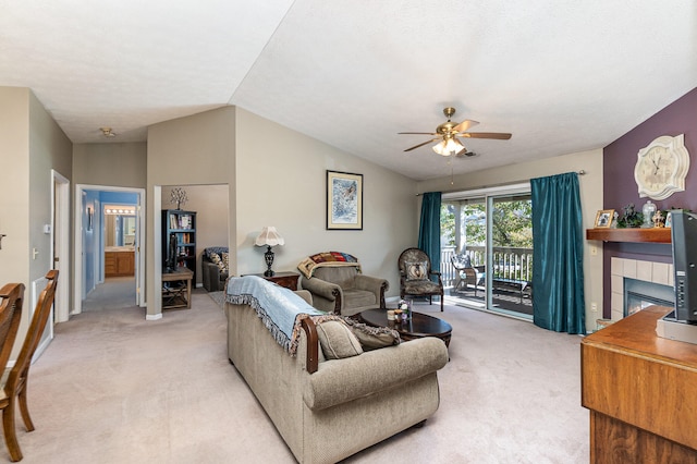 carpeted living room featuring vaulted ceiling, ceiling fan, and a fireplace