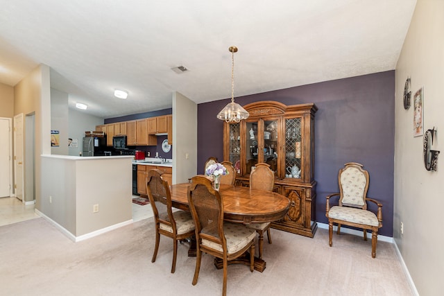 dining space featuring a textured ceiling, light colored carpet, sink, and an inviting chandelier