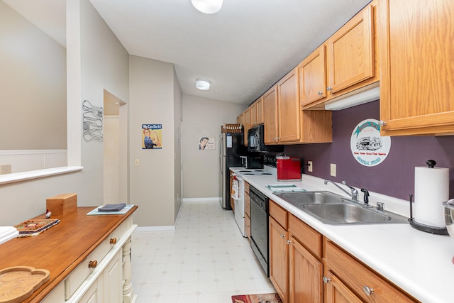 kitchen with sink, black appliances, and lofted ceiling