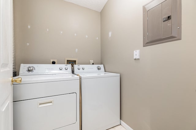 laundry room featuring electric panel, a textured ceiling, and washing machine and clothes dryer