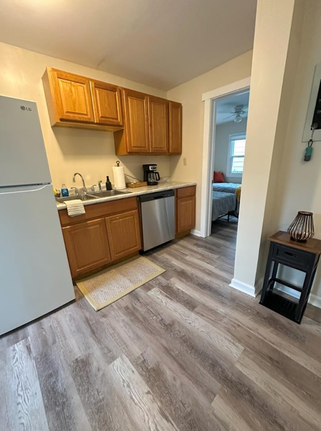 kitchen featuring dishwasher, light hardwood / wood-style flooring, sink, white refrigerator, and ceiling fan