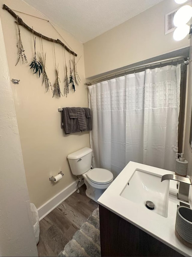 bathroom featuring toilet, a textured ceiling, vanity, and wood-type flooring