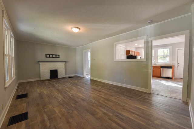 unfurnished living room featuring crown molding, a fireplace, and dark hardwood / wood-style floors