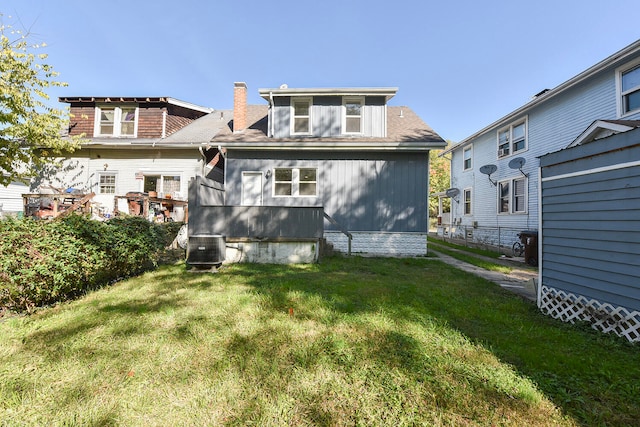 rear view of property with a lawn and central AC unit