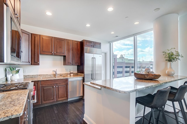 kitchen featuring sink, light stone countertops, stainless steel appliances, and dark hardwood / wood-style floors