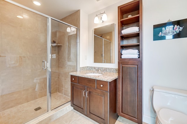 bathroom featuring toilet, an enclosed shower, vanity, and tile patterned floors