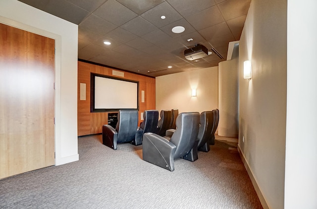 cinema room featuring carpet flooring and wooden walls