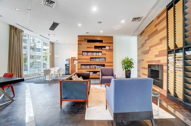 living room featuring wooden walls and a fireplace