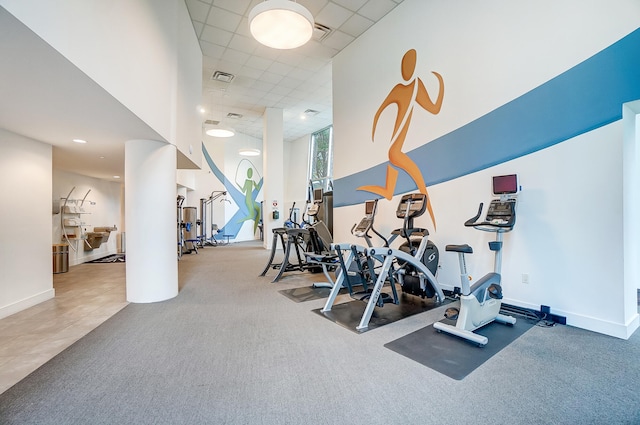 workout area featuring a drop ceiling and tile patterned flooring