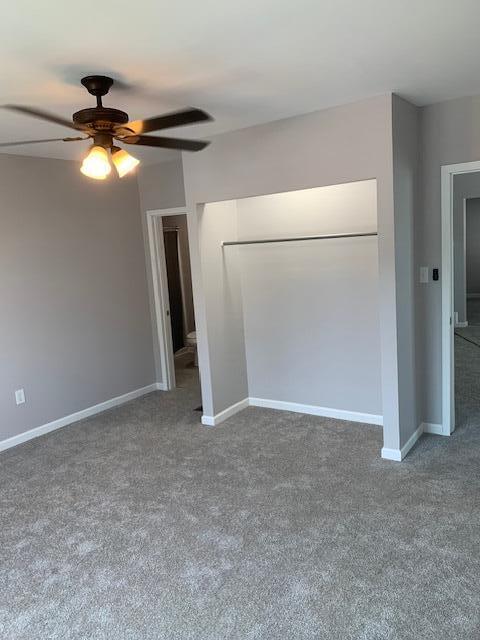 carpeted empty room featuring ceiling fan