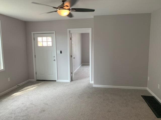 foyer with ceiling fan and light colored carpet