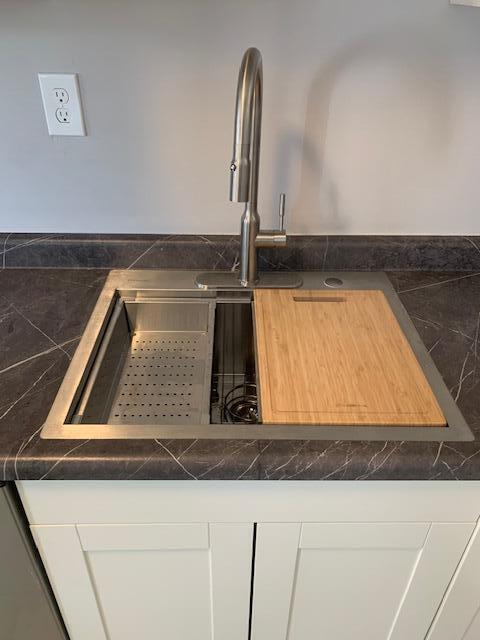 interior details with white cabinetry and sink