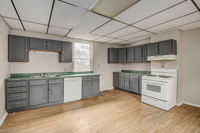 kitchen with gray cabinets, light wood-type flooring, white appliances, and sink