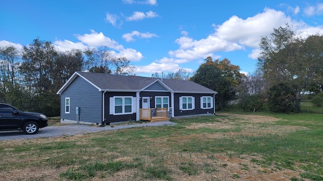 single story home featuring covered porch and a front lawn