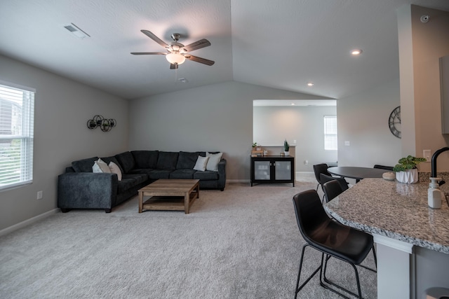 living room with ceiling fan, light colored carpet, and lofted ceiling