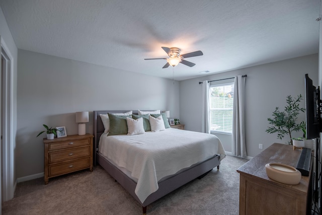 carpeted bedroom featuring ceiling fan and a textured ceiling