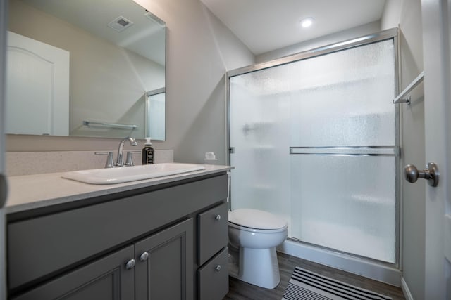 bathroom featuring hardwood / wood-style flooring, vanity, toilet, and an enclosed shower