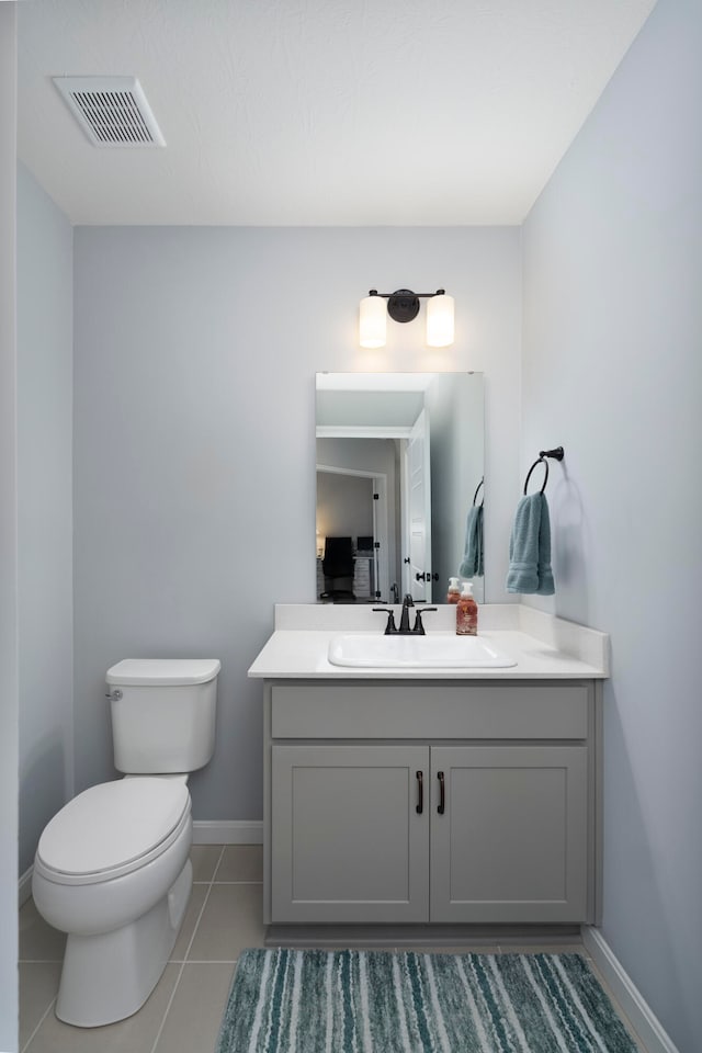 bathroom with vanity, toilet, and tile patterned flooring