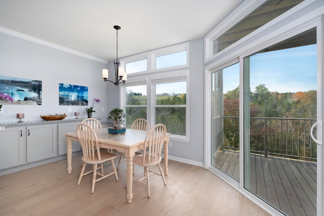 dining area with a chandelier, ornamental molding, light hardwood / wood-style flooring, and plenty of natural light