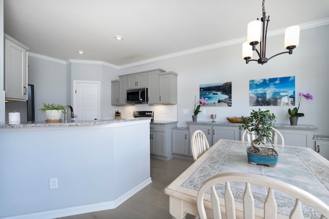 kitchen featuring backsplash, a chandelier, ornamental molding, pendant lighting, and gray cabinets