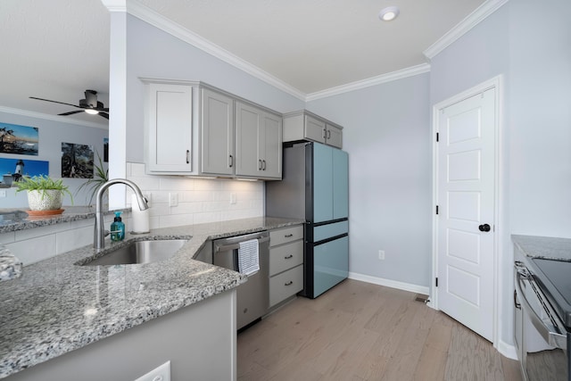 kitchen featuring backsplash, appliances with stainless steel finishes, light stone countertops, light hardwood / wood-style floors, and sink