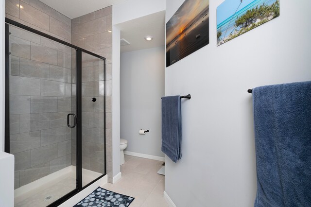 bathroom with toilet, a shower with shower door, and tile patterned flooring