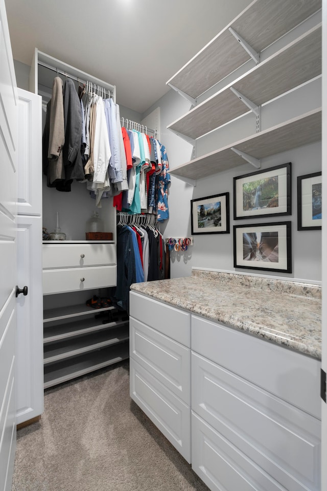 walk in closet featuring light colored carpet