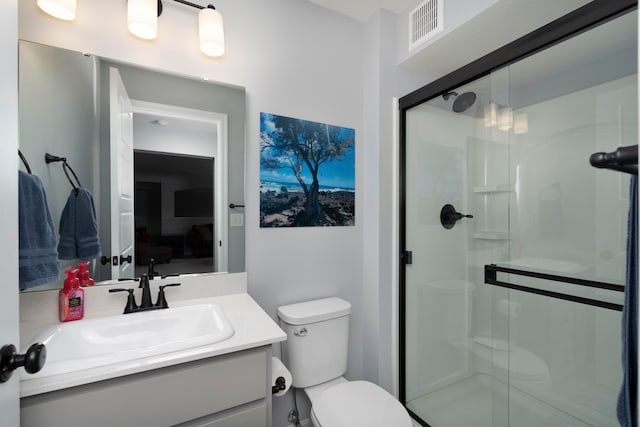 bathroom featuring vanity, toilet, and walk in shower