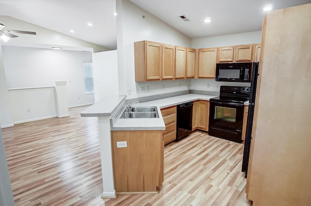 kitchen with lofted ceiling, sink, black appliances, light hardwood / wood-style floors, and kitchen peninsula