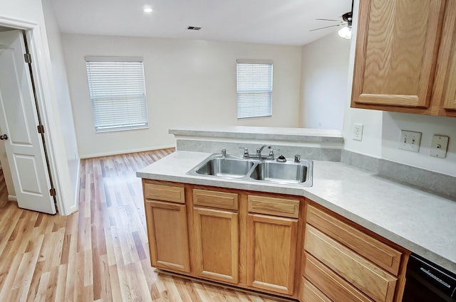 kitchen with sink, kitchen peninsula, ceiling fan, and light hardwood / wood-style flooring