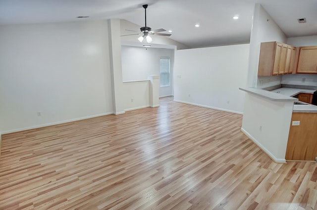 kitchen featuring vaulted ceiling, ceiling fan, and light wood-type flooring