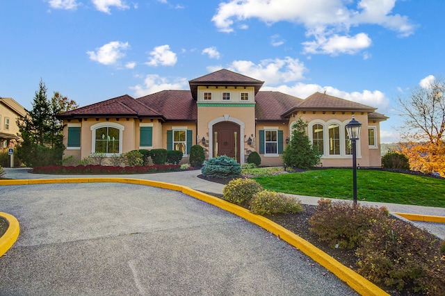 mediterranean / spanish-style home featuring a front lawn