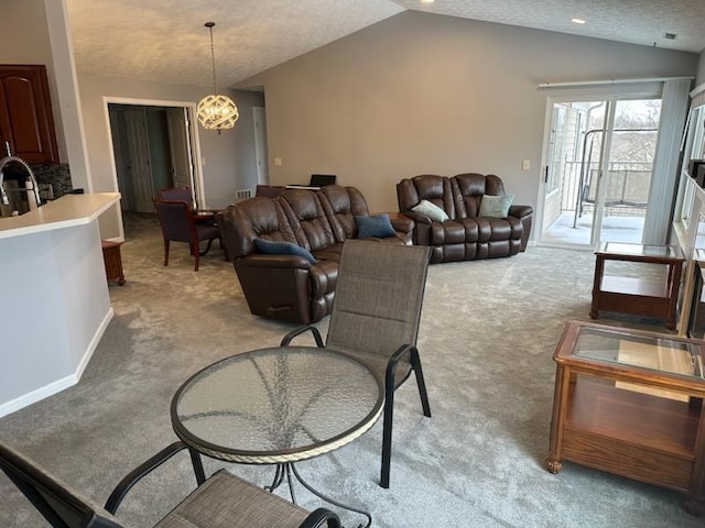 living area with lofted ceiling, light colored carpet, an inviting chandelier, a textured ceiling, and baseboards