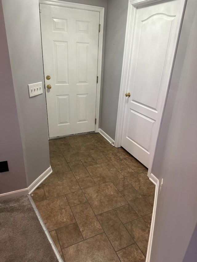 doorway featuring stone finish flooring and baseboards